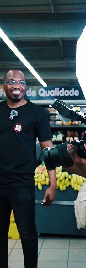 Membro da equipa PAG SISTEM a sorrir durante uma gravação num supermercado